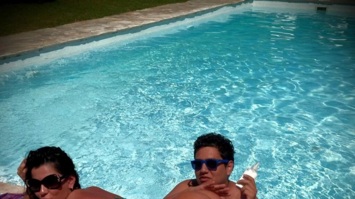 Karina deja que su amigo le pase bronceador en la cola