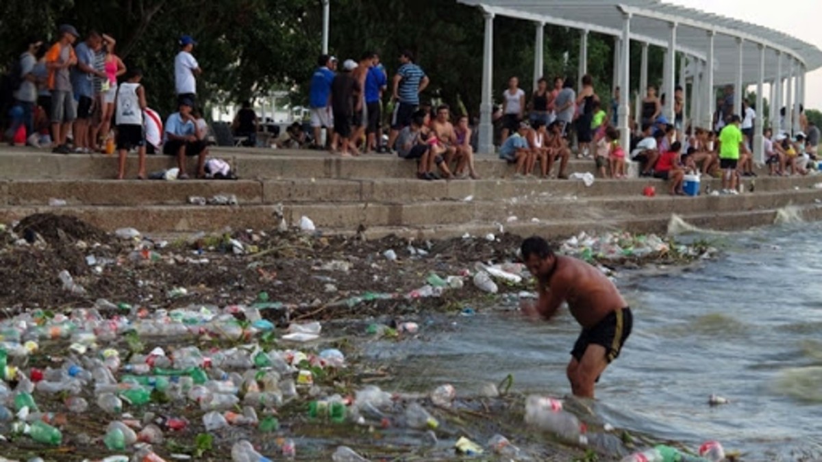 Para pasar el calor, la gente se baña entre la basura